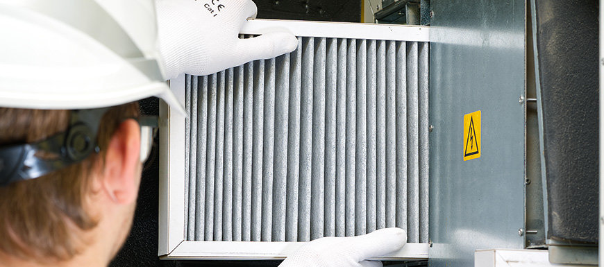 Technician installing a furnace filter